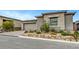 Single-story home with a stone facade, two-car garage, and beautifully landscaped front yard at 977 Edinburgh Fields Ct, Las Vegas, NV 89138