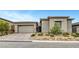 Charming single-story home featuring a stone facade, desert landscaping, and brick driveway at 977 Edinburgh Fields Ct, Las Vegas, NV 89138