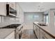 Contemporary kitchen with gas cooktop, marble countertops, and breakfast bar overlooking the living area at 977 Edinburgh Fields Ct, Las Vegas, NV 89138