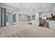 Spacious living area with carpet flooring, ceiling fans, and access to a kitchen and outdoor area at 977 Edinburgh Fields Ct, Las Vegas, NV 89138