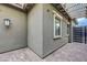 Covered patio with stone flooring and stucco walls, featuring a modern light fixture at 977 Edinburgh Fields Ct, Las Vegas, NV 89138