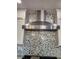 Stainless steel vent hood over a modern gas range with mosaic backsplash at , Henderson, NV 89002