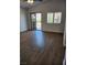 Open-concept living room featuring wood floors, a ceiling fan, a window, and sliding glass doors to a balcony at , Henderson, NV 89002
