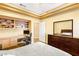 Bedroom boasts a tray ceiling, a built-in desk, and a dark wood dresser with mirror at 10125 Hope Island Dr, Las Vegas, NV 89134