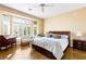 Bright bedroom featuring a bay window with shutters, a king bed, and wood flooring at 10125 Hope Island Dr, Las Vegas, NV 89134
