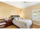 Cozy bedroom showcases wood-look floors, a comfortable bed, and a window overlooking the front yard at 10125 Hope Island Dr, Las Vegas, NV 89134