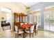 Well-lit dining room with a classic dining set, hutch, chandelier, tile floors, and a view of the backyard through plantation shutters at 10125 Hope Island Dr, Las Vegas, NV 89134
