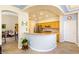 Open kitchen with breakfast bar, modern appliances, and arched entryway to the living room at 10125 Hope Island Dr, Las Vegas, NV 89134
