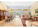 Open-concept living room with neutral-toned walls, tile flooring, plantation shutters, and natural light, adjacent to the dining area at 10125 Hope Island Dr, Las Vegas, NV 89134