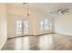 Open concept living space with modern light fixture, doors to balcony, and large windows providing ample light at 10147 Aspen Rose St # 101, Las Vegas, NV 89183