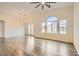 Bright, open living room featuring high ceilings, large windows, a modern ceiling fan and wood-style flooring at 10147 Aspen Rose St # 101, Las Vegas, NV 89183