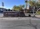 Community entrance featuring a decorative stone sign and well-maintained landscaping on a sunny day at 10147 Aspen Rose St # 101, Las Vegas, NV 89183