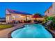 Lush backyard with sparkling pool, covered patio, and built-in outdoor kitchen, creating an ideal space for relaxation at 1028 Dodger Blue Ave, Las Vegas, NV 89123