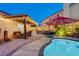 Captivating backyard featuring pool, outdoor kitchen, covered patio, and lush landscaping, creating a perfect space at 1028 Dodger Blue Ave, Las Vegas, NV 89123