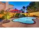 Charming backyard oasis with a refreshing pool, soothing water feature, and cozy lounging area under a vibrant umbrella at 1028 Dodger Blue Ave, Las Vegas, NV 89123