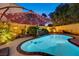 Inviting backyard featuring a pool, rock water feature, and covered patio, creating a peaceful space for relaxation at 1028 Dodger Blue Ave, Las Vegas, NV 89123