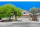 Charming two-story home featuring a three-car garage and lush green trees creating curb appeal at 1028 Dodger Blue Ave, Las Vegas, NV 89123