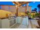 Outdoor kitchen featuring a built-in grill, refrigerator, and bar, creating the perfect space for al fresco dining at 1028 Dodger Blue Ave, Las Vegas, NV 89123