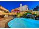 Beautiful pool with rock waterfall feature, tropical landscaping, and outdoor kitchen at 1028 Dodger Blue Ave, Las Vegas, NV 89123