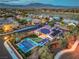 Stunning aerial view of a home with a pool, putting green, solar panels, and beautiful mountain views at 10319 Larkmead Ave, Las Vegas, NV 89149
