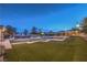 Expansive backyard boasting lush artificial turf, an outdoor bar, putting green, and inviting lounge areas for relaxation at 10319 Larkmead Ave, Las Vegas, NV 89149
