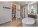 Bright bathroom featuring a standalone tub, walk-in closet, vanity, and custom tile work at 10319 Larkmead Ave, Las Vegas, NV 89149