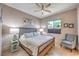Cozy bedroom showcasing a ceiling fan, neutral walls, matching lamps, and a comfortable chair at 10319 Larkmead Ave, Las Vegas, NV 89149