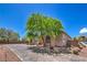 Home exterior featuring a paved driveway, desert landscaping, and an arched entryway at 10319 Larkmead Ave, Las Vegas, NV 89149