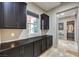 Hallway with dark cabinetry, granite countertops, and views into the bathroom at 10319 Larkmead Ave, Las Vegas, NV 89149