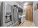 Well-equipped laundry room featuring front load washer and dryer with cabinet storage and tiled flooring at 10319 Larkmead Ave, Las Vegas, NV 89149