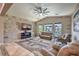 Spacious living room with stone accent wall, ceiling fan, and plush seating area perfect for relaxation at 10319 Larkmead Ave, Las Vegas, NV 89149