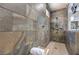 A close up of the walk-in shower in the main bathroom with a bench and wall mounted shower head at 10319 Larkmead Ave, Las Vegas, NV 89149