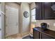 Mud room with a white door, dark cabinets, a small window, and tile floors at 10319 Larkmead Ave, Las Vegas, NV 89149