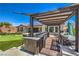 Cook under the pergola in the outdoor kitchen next to the pool and putting green in this backyard at 10319 Larkmead Ave, Las Vegas, NV 89149