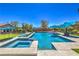 Beautiful swimming pool with spa, putting green, lounge seating, and umbrellas to enjoy the outdoor space at 10319 Larkmead Ave, Las Vegas, NV 89149