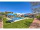 Backyard oasis boasts a sparkling pool, green grass, lounge seating, and outdoor space for relaxing and entertaining at 10319 Larkmead Ave, Las Vegas, NV 89149
