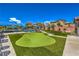 Sprawling backyard with an artificial turf putting green, lounge area, and mountain views at 10319 Larkmead Ave, Las Vegas, NV 89149