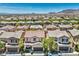 An aerial view showcases a neighborhood's charming two-story homes against a mountainous backdrop at 10353 Yew Blossom Ave, Las Vegas, NV 89166