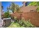 Green backyard featuring a brick wall, plants, and AC unit at 10353 Yew Blossom Ave, Las Vegas, NV 89166
