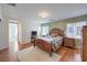 Primary bedroom with hardwood floors, a large bed, and a view of the ensuite bathroom at 10353 Yew Blossom Ave, Las Vegas, NV 89166