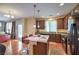 Charming kitchen with wood floors, central island with seating, granite countertops, and stainless appliances at 10353 Yew Blossom Ave, Las Vegas, NV 89166