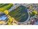 This aerial shot highlights a scenic pond and golf course within the community, bordered by lush greenery and walking paths at 10361 Profeta Ct, Las Vegas, NV 89135