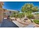Landscaped backyard featuring a water fountain, mature trees, and lush greenery at 10361 Profeta Ct, Las Vegas, NV 89135