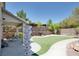 A well-manicured backyard featuring lush green grass, decorative columns, patio seating, and a built-in BBQ area, perfect for outdoor living at 10554 Lilac Tree Ave, Las Vegas, NV 89135