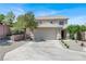 Two-story home featuring a tan exterior, tile roof, well-maintained landscaping, and a two-car garage at 10554 Lilac Tree Ave, Las Vegas, NV 89135