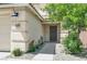 Up close shot of a gray front door with flowers and a small tree alongside a 2-car garage at 10554 Lilac Tree Ave, Las Vegas, NV 89135