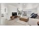 Bright and open living room features light wood floors, modern furniture, and a staircase at 10554 Lilac Tree Ave, Las Vegas, NV 89135