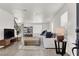 Bright living room featuring modern furniture, light wood floors, a staircase, and a large window at 10554 Lilac Tree Ave, Las Vegas, NV 89135