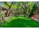 Serene backyard showcasing an expansive lawn, shaded by mature trees, perfect for outdoor activities and relaxation at 108 Quail Run Rd, Henderson, NV 89014