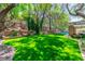 A spacious backyard with lush green lawn, mature trees, and landscaped features, perfect for outdoor activities at 108 Quail Run Rd, Henderson, NV 89014